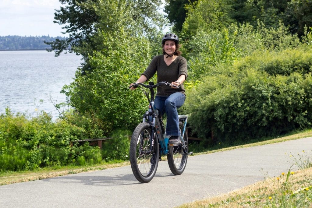 Woman enjoys a ride on an electric bike along a beautiful scenic path in Seattle, Washington.